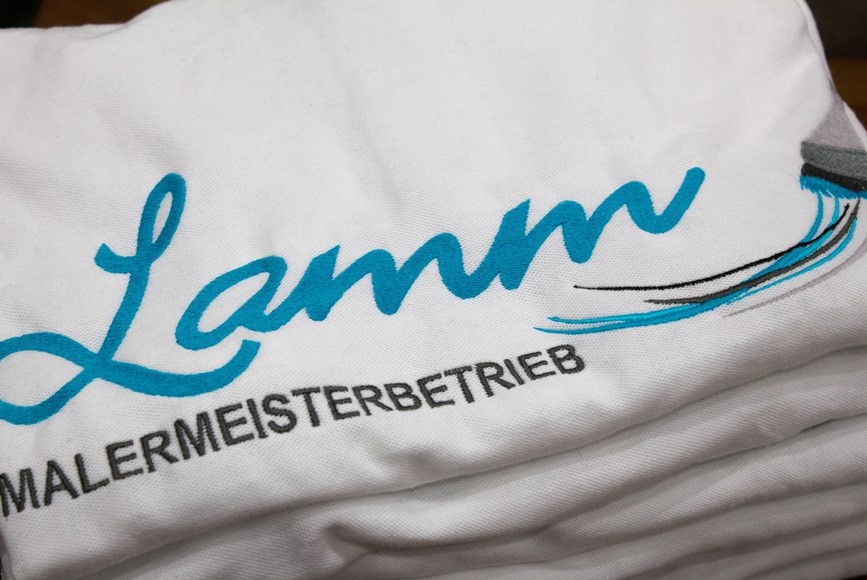 Logo Malerbetrieb gestickt auf weißen Poloshirts